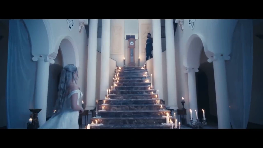 A symmetrical staircase lined with candles in a cool-blue interior.