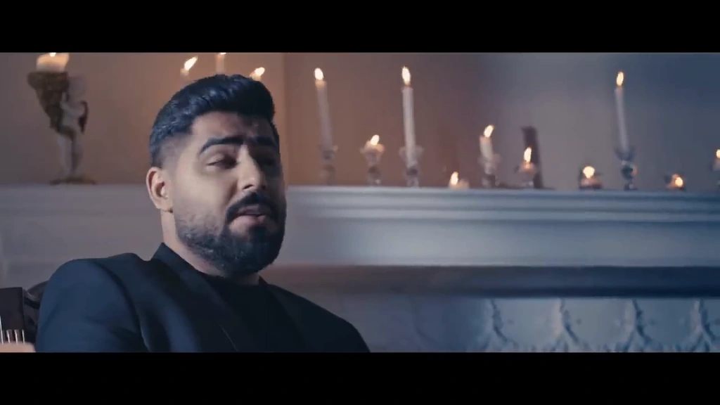 A close portrait of Akhras with candles behind him.