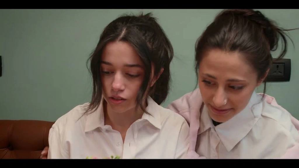 Two women in white shirts sharing a quiet moment inside the café.