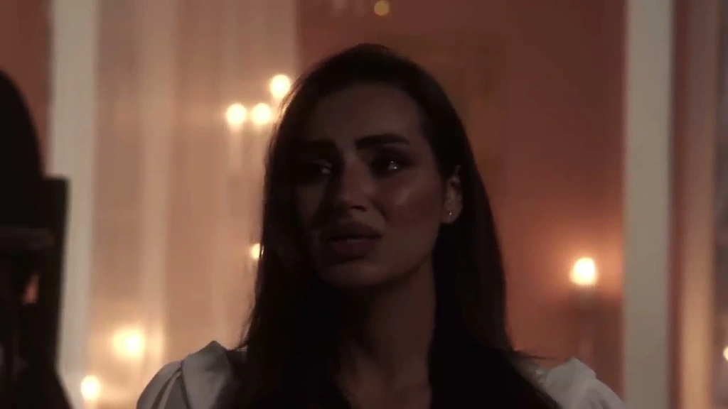 A woman in profile with warm candlelight behind her.