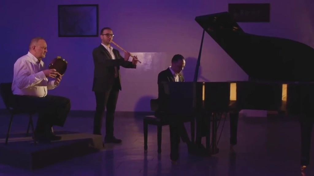Three musicians perform around a grand piano in violet stage light.