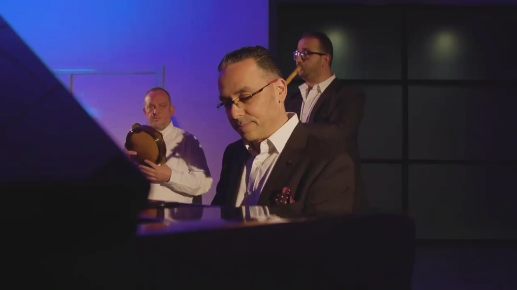 The pianist is framed across the instrument with the other musicians behind him.