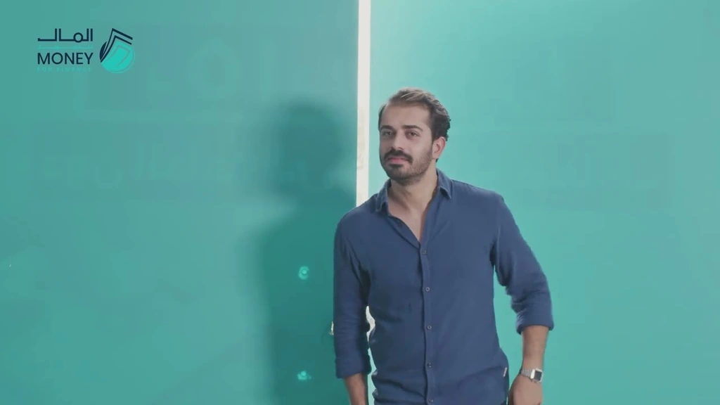 A man beside a turquoise office wall in the Money for Finance commercial.
