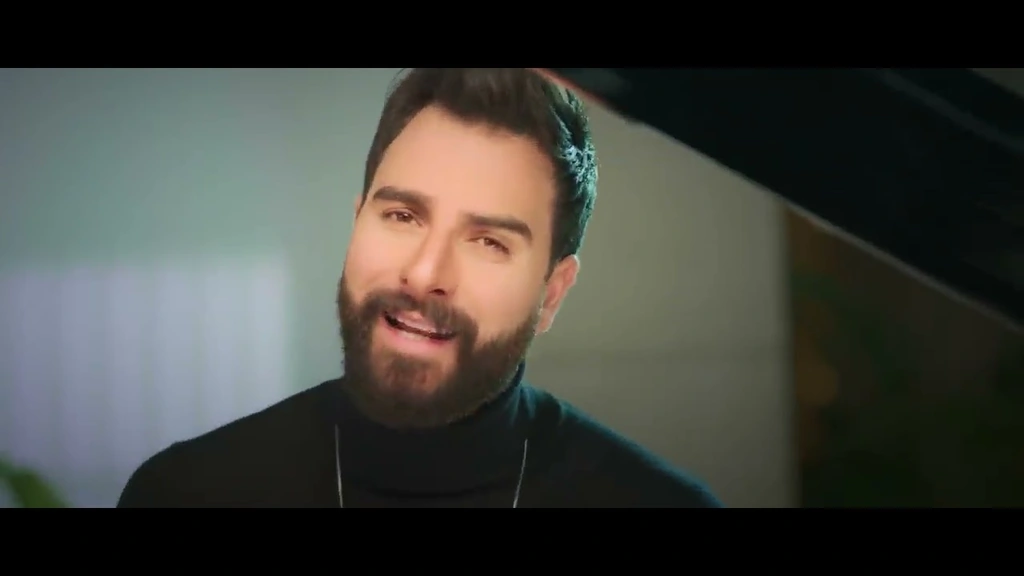 Toni Qattan singing beside a bright window.