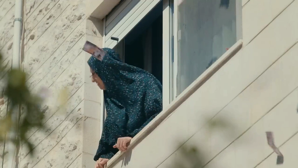 A comic character in a patterned headscarf leans over a pale stair railing.