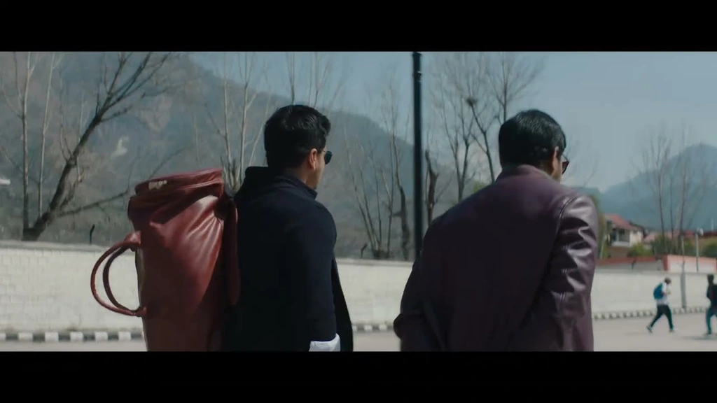 SPY — Two men seen from behind along a mountain road.