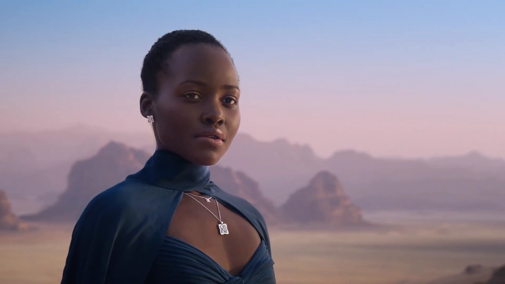 Lupita Nyong’o against softly lit pink sandstone mountains at dusk.